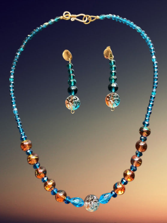 Necklace and earrings with blue and orange beads on a gradient background