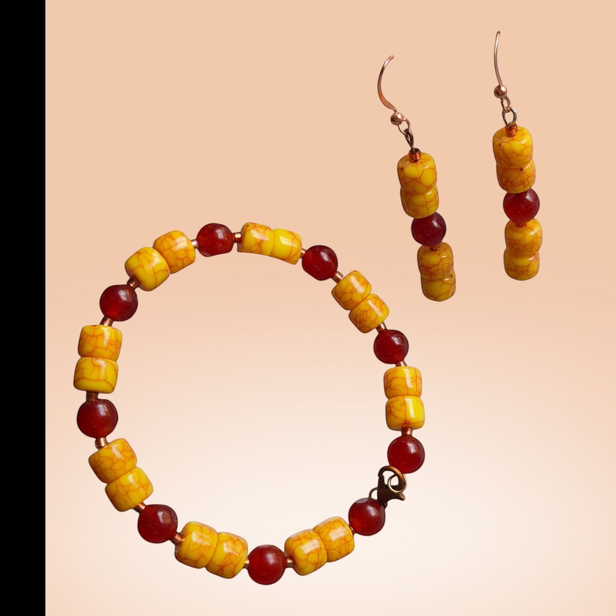 Heartfelt Creations jewelry set featuring a beaded bracelet and drop earrings with yellow crackle and red accent beads.