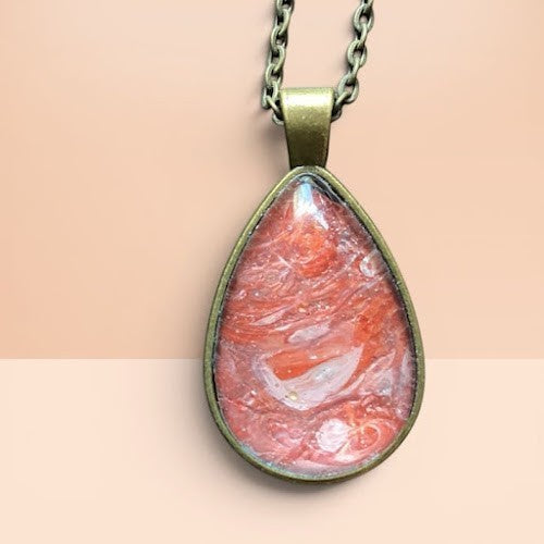 Heartfelt Creations teardrop necklace with a marbled coral and peach resin pendant in an antique bronze setting.