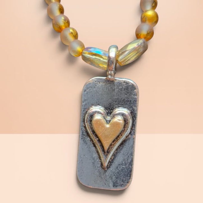 Necklace with a heart-shaped pendant on a beige background