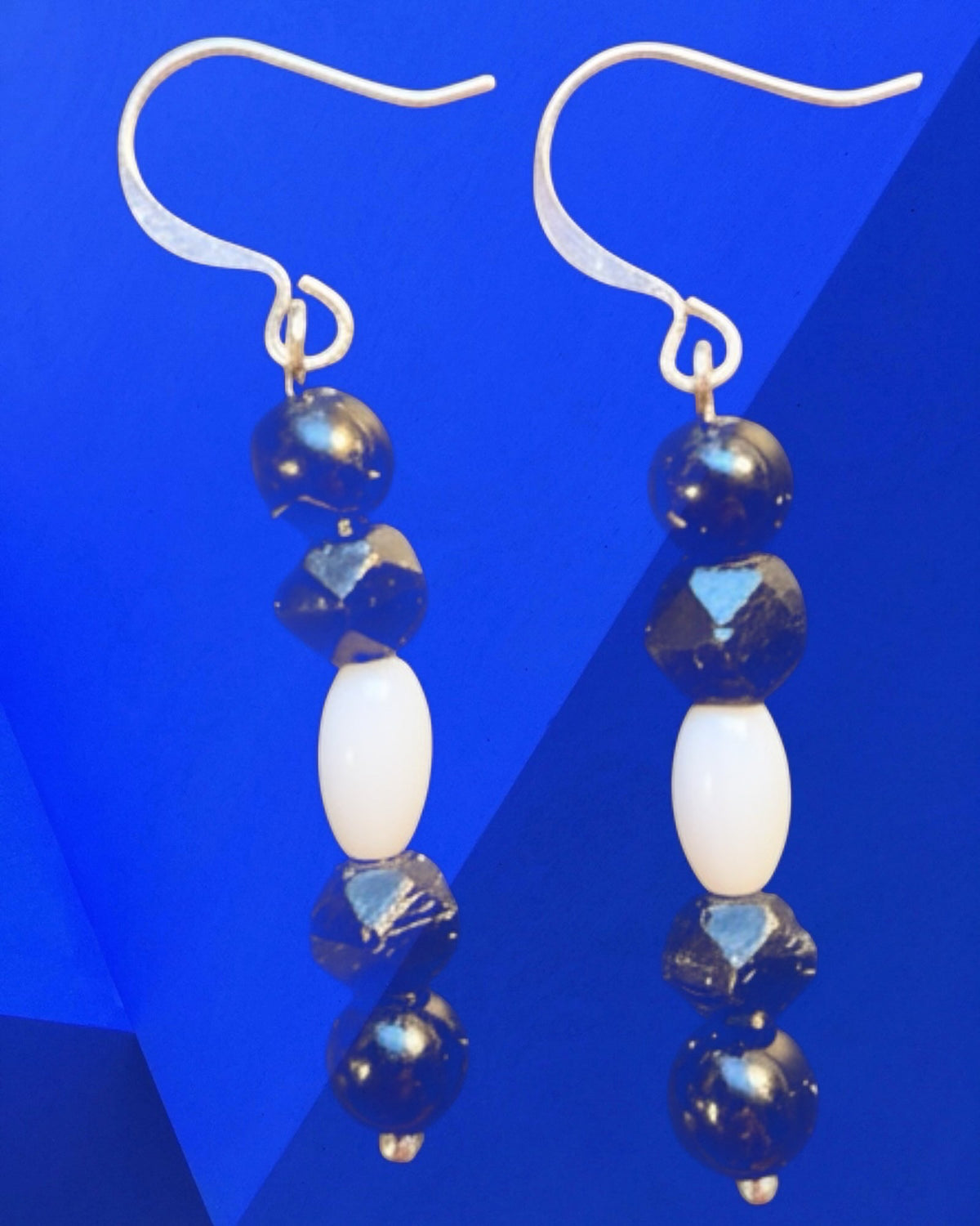 Heartfelt Creations drop earrings featuring black faceted beads and smooth white oval beads on silver hooks