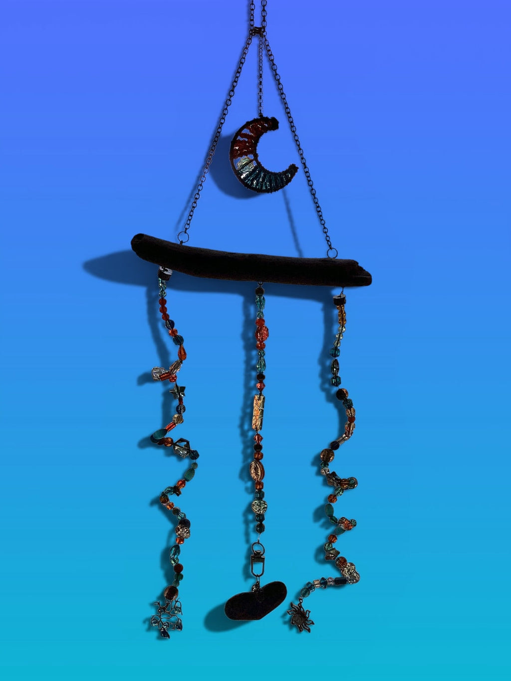 Decorative wind chime with glass and stone beads, twirling down from a piece of  Driftwood collected from the Pacific Ocean.    The beads are brilliant turquoise & orange  colors interspersed with grey crystal stars.