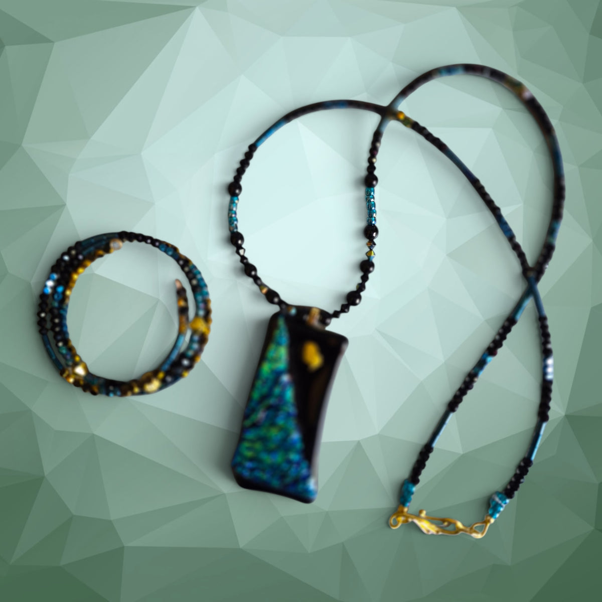 Heartfelt Creations artisan jewelry set with a dichroic glass pendant and beaded necklace and wrap bracelet.