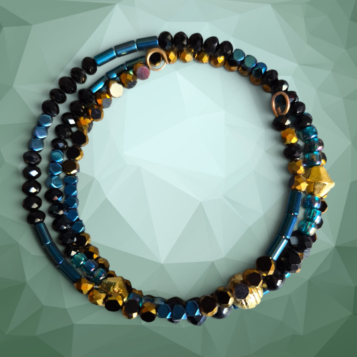Heartfelt Creations artisan beaded necklace and bracelet set with iridescent blue, black, and gold glass beads.
