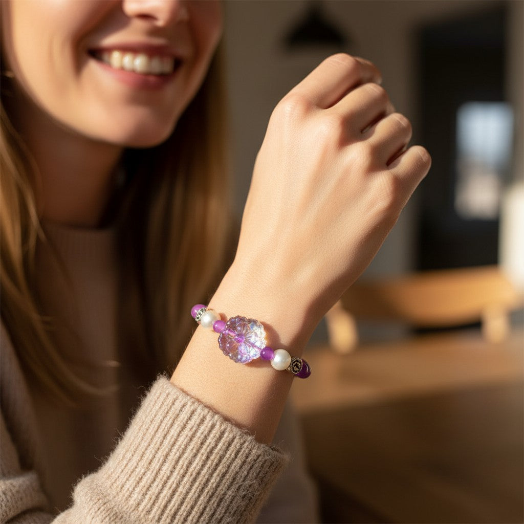 This delightful hand crafted bracelet is a perfect way to add a pop to any outfit.   A beaded stretch bracelet features purple, lavendar and magenta beads, white pearl-like beads, silver-toned spacer details, and a central clear acrylic flower charm.  Simple yet Stunning!