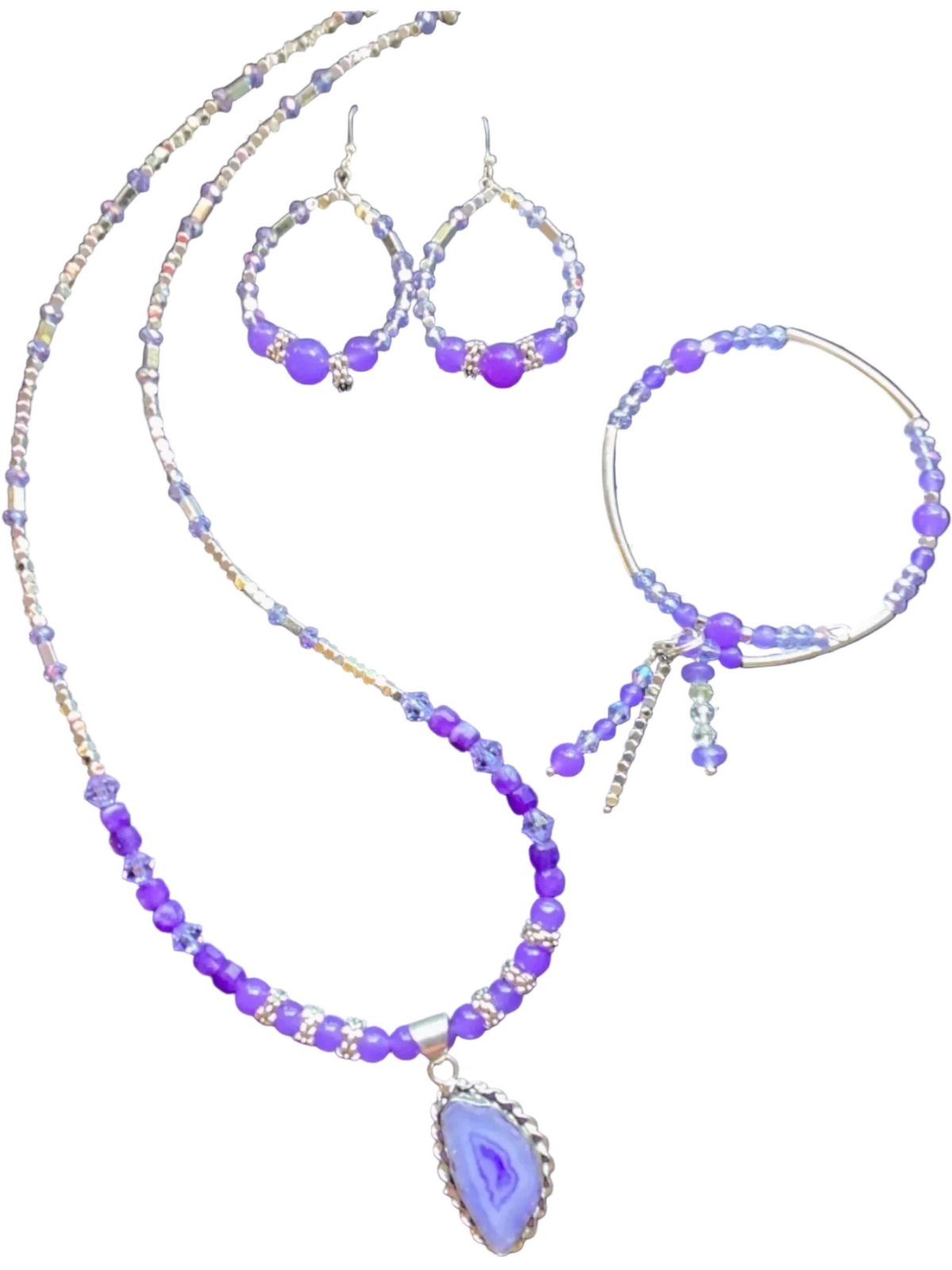 Handcrafted jewelry set featuring a purple agate teardrop pendant necklace, matching beaded hoop earrings, and a beaded charm bracelet with dangling silver accents against a clean white background