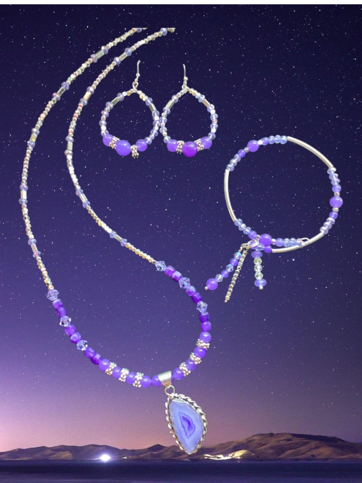 Purple beaded necklace, earrings, and bracelet set against a starry night sky with mountains.