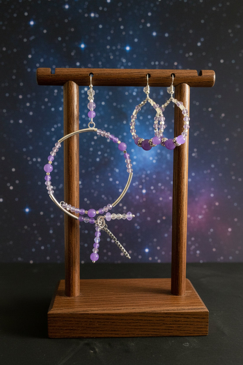 Handcrafted jewelry set featuring a purple agate teardrop pendant necklace, matching beaded hoop earrings, and a beaded charm bracelet with dangling silver accents against a clean white background