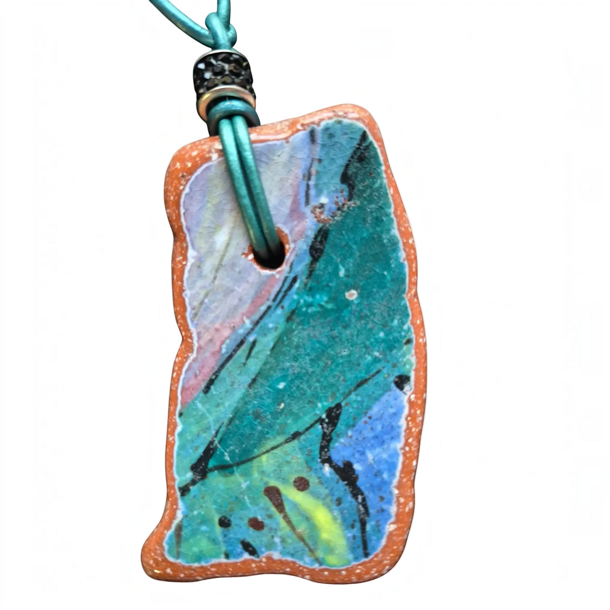 Heartfelt Creations artisan ceramic pendant necklace with crackled teal blue and pink glaze on a teal leather cord.
