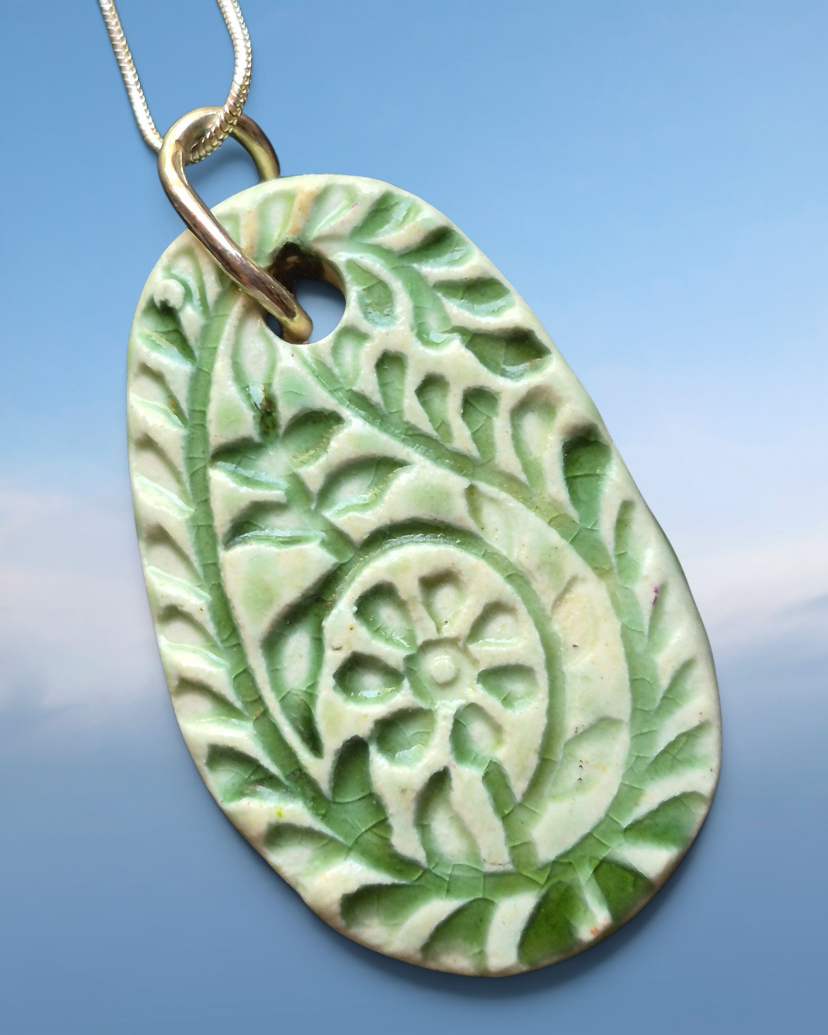 Heartfelt Creations handcrafted ceramic pendant necklace with sage-green floral crackle glaze on a silver-tone chain.