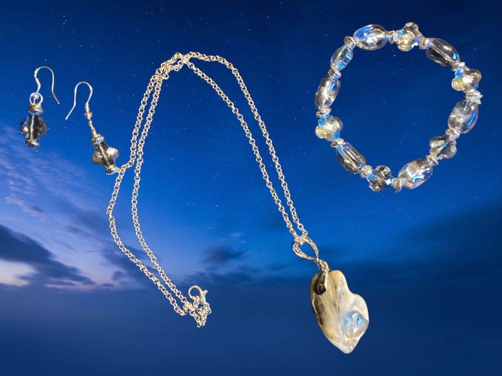 Jewelry set with necklace, earrings, and bracelet against a blue sky background