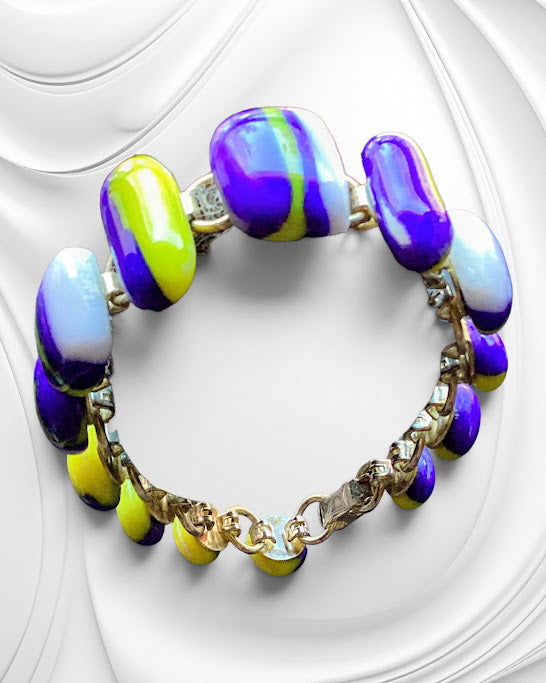 Colorful beaded bracelet with gold chain on a white background