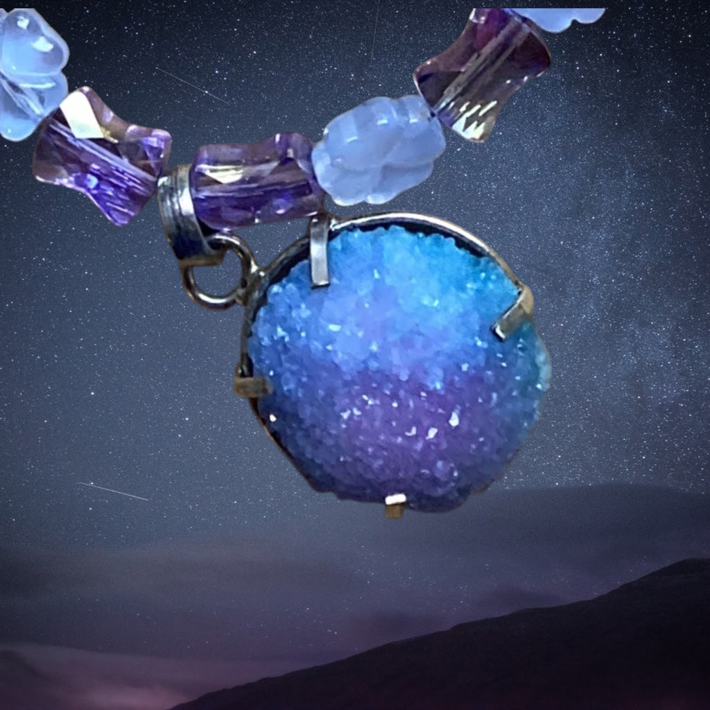 Necklace with a blue and purple crystal pendant against a starry night sky background