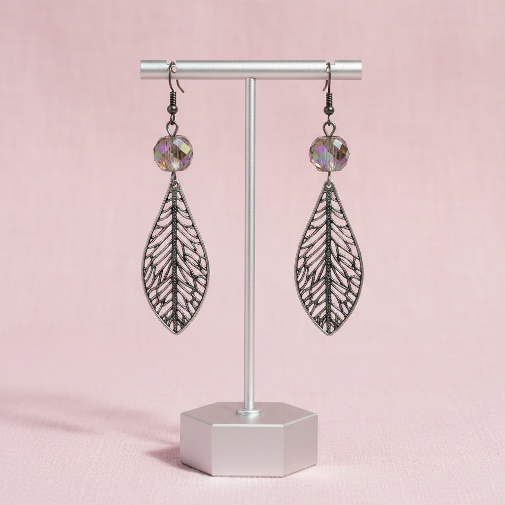 A pair of silver-toned dangle earrings with intricate filigree leaf-shaped pendants and faceted iridescent beads at the top, shown on a plain white background.