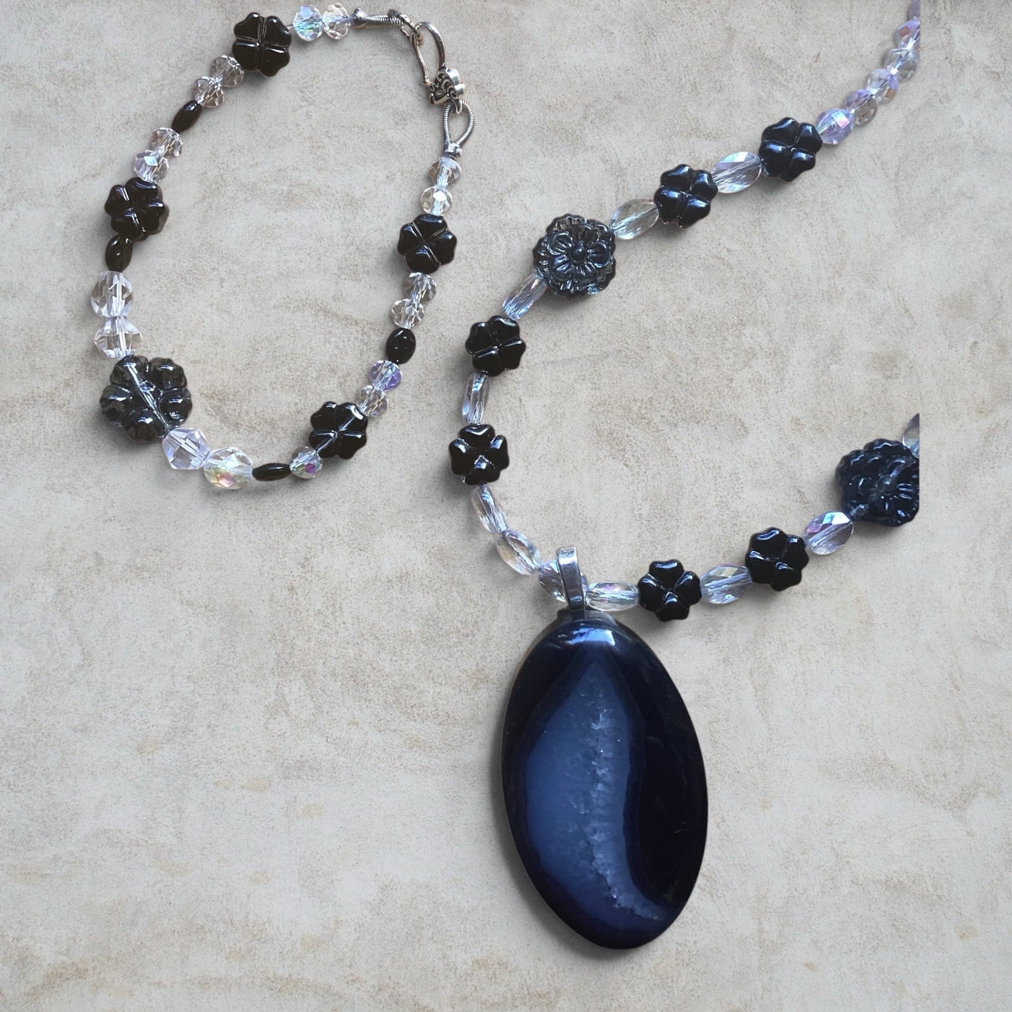 Heartfelt Creations handcrafted necklace and bracelet set with a dark agate pendant, black floral beads, and crystals.