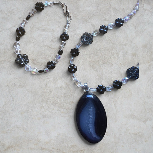 Heartfelt Creations handcrafted necklace and bracelet set with a dark agate pendant, black floral beads, and crystals.