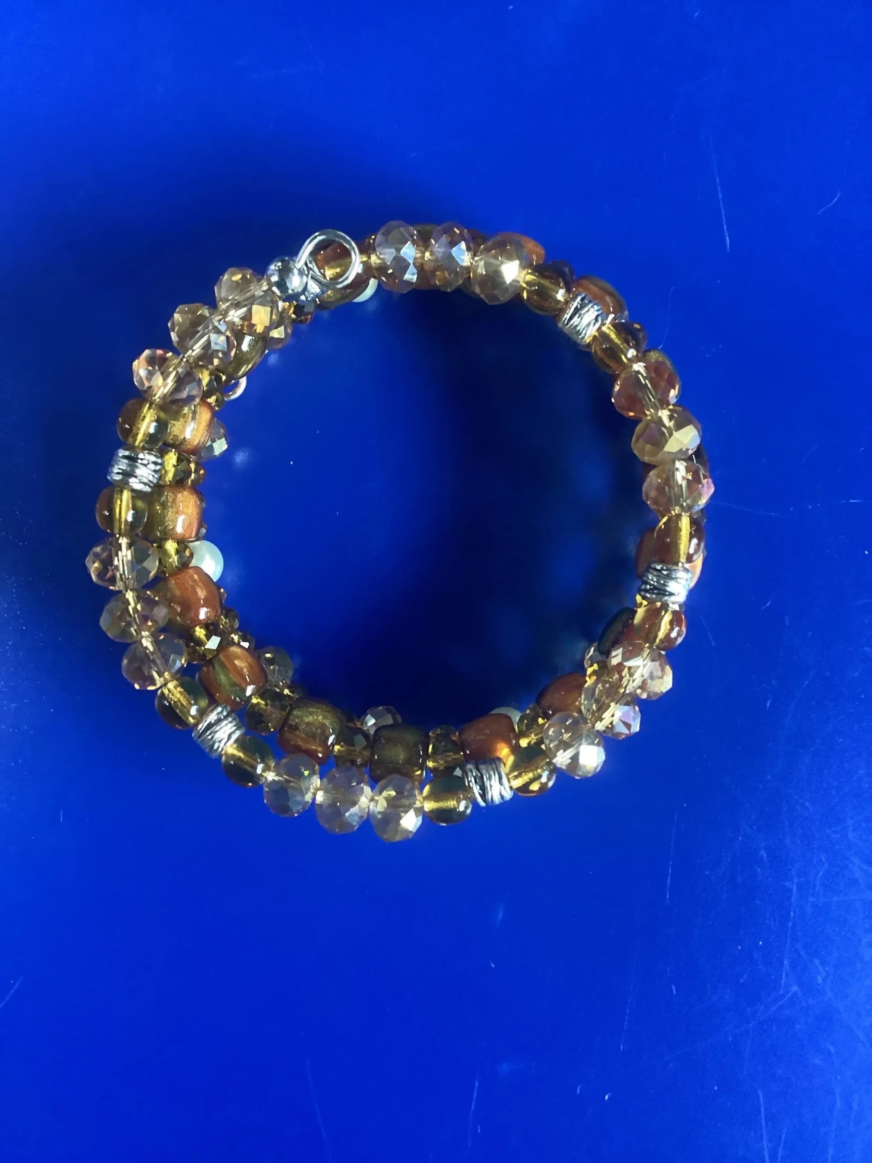 Heartfelt Creations multi-strand coil bracelet with amber, clear faceted beads, and silver accents. Adjustable wrap design.