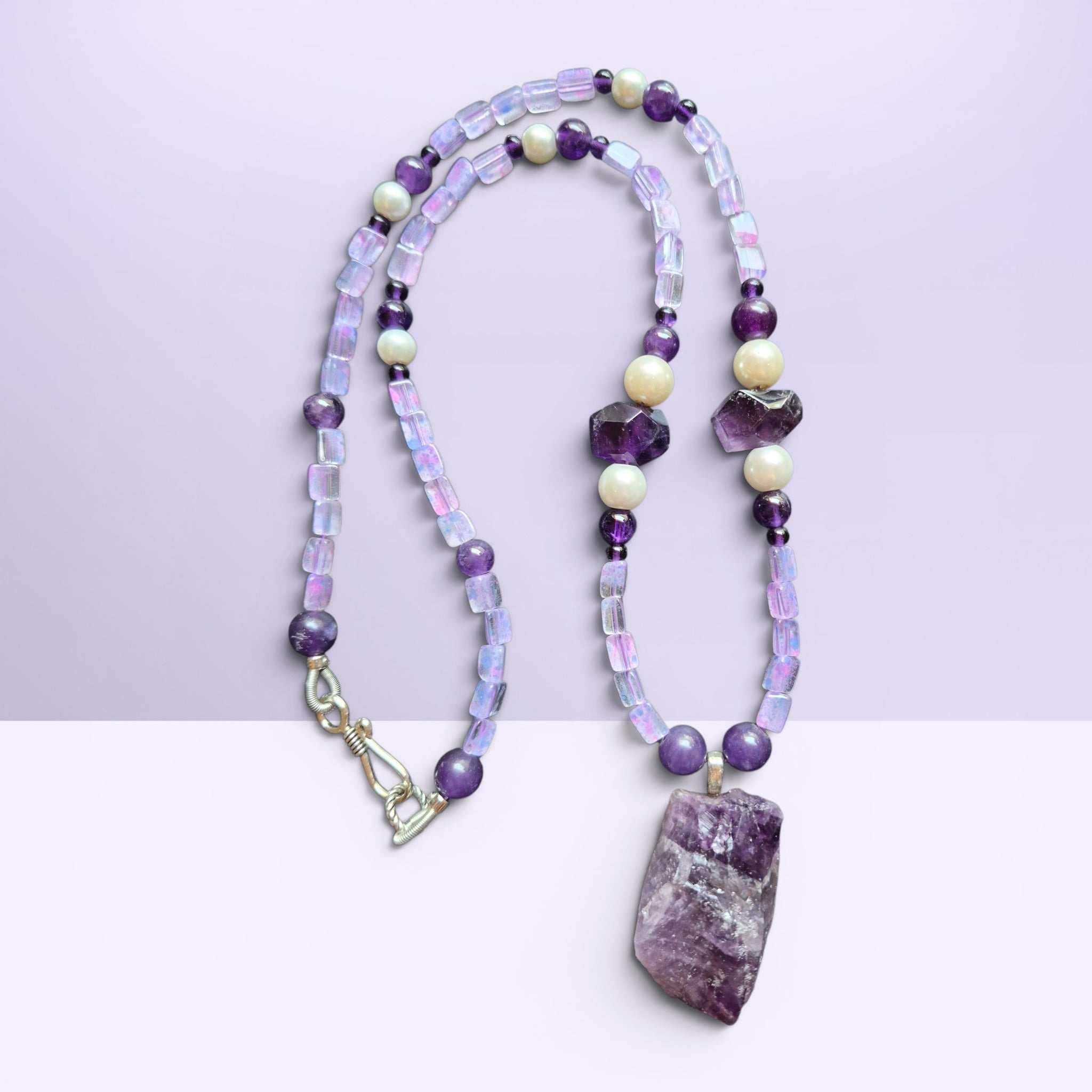 Heartfelt Creations bohemian beaded necklace featuring raw amethyst pendant, iridescent beads, and lustrous pearls.