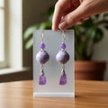 Heartfelt Creations floral dangle earrings with lilac ceramic beads and geometric amethyst pendants on silver hooks.