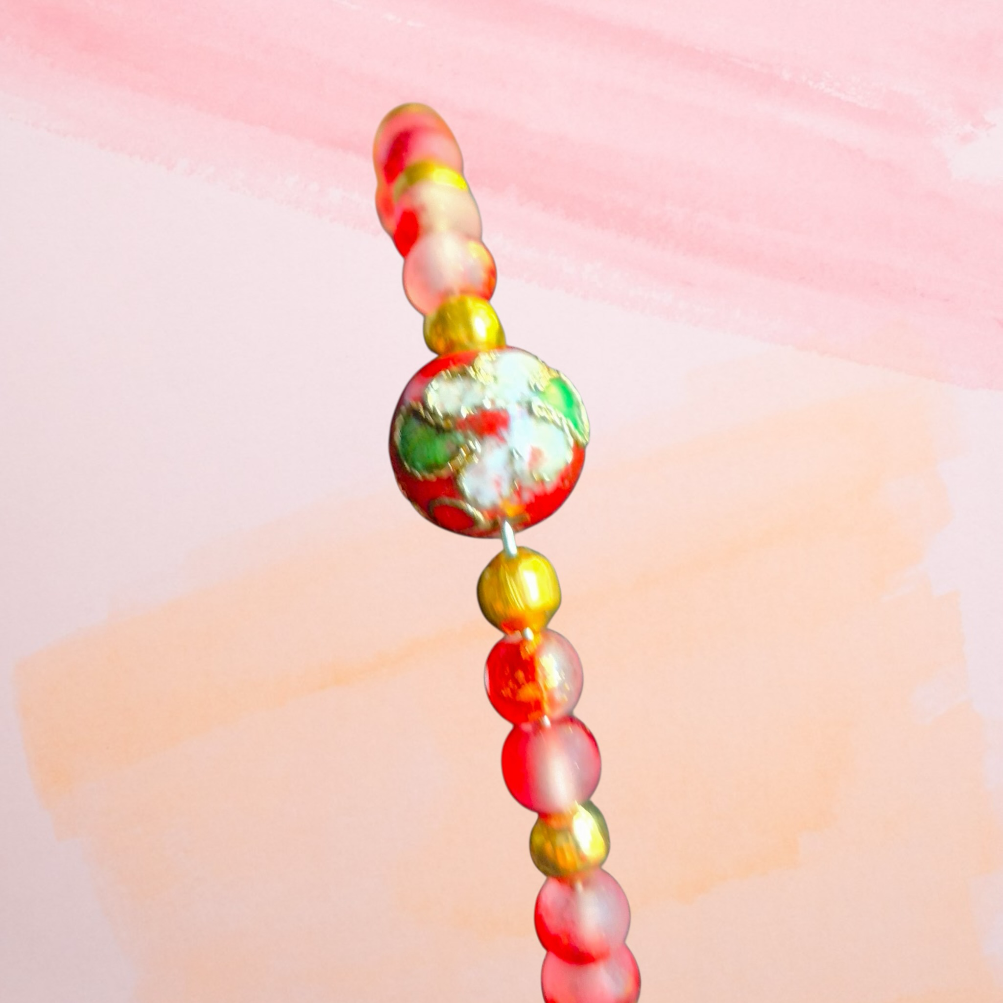 Heartfelt Creations beaded bracelet with frosted pink, red, and gold beads. Features a decorative centerpiece bead.