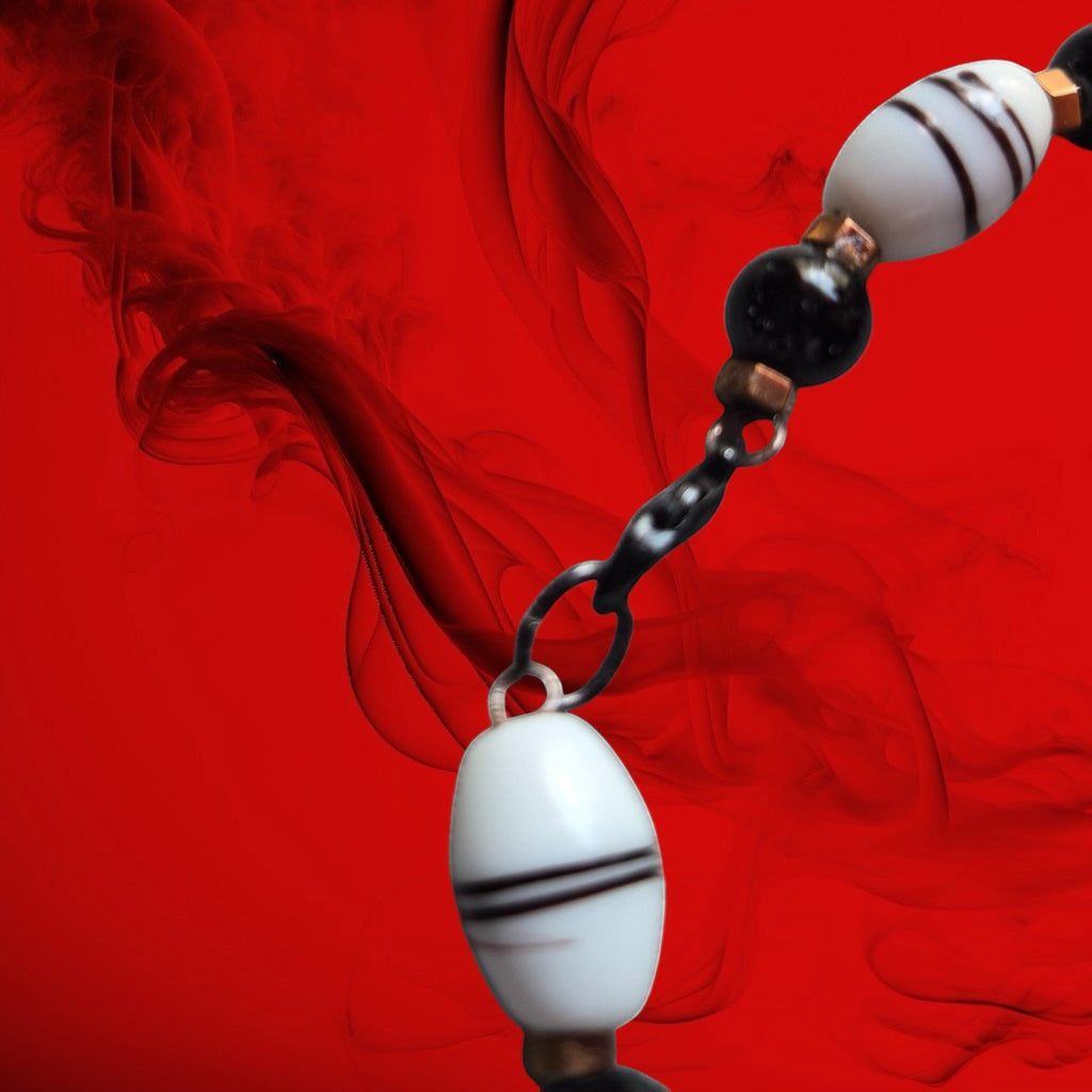 Heartfelt Creations beaded bracelet with black beads, striped white oval beads, and a silver-toned dolphin charm.