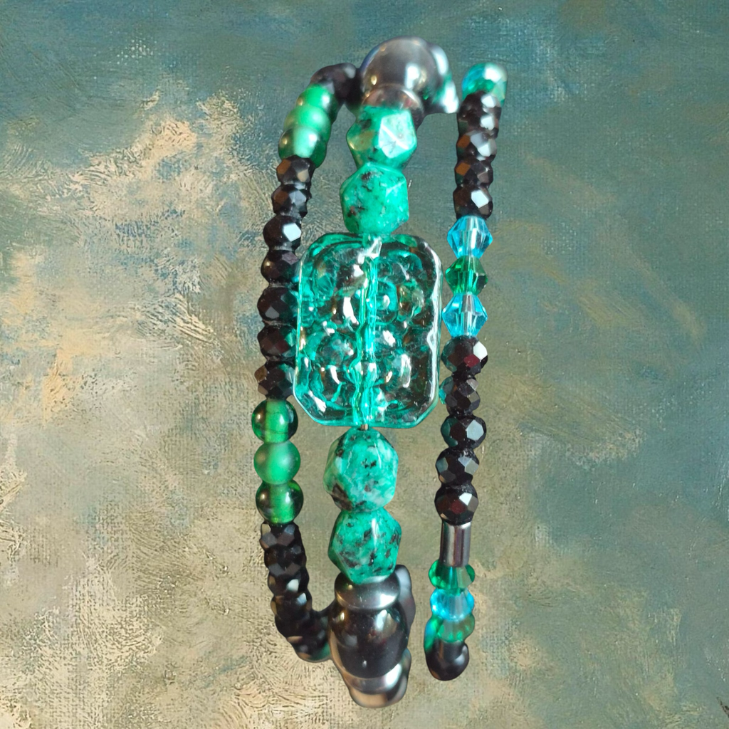 Heartfelt Creations artisan beaded bracelet with green, blue, and black beads, featuring a large turquoise stone pendant.