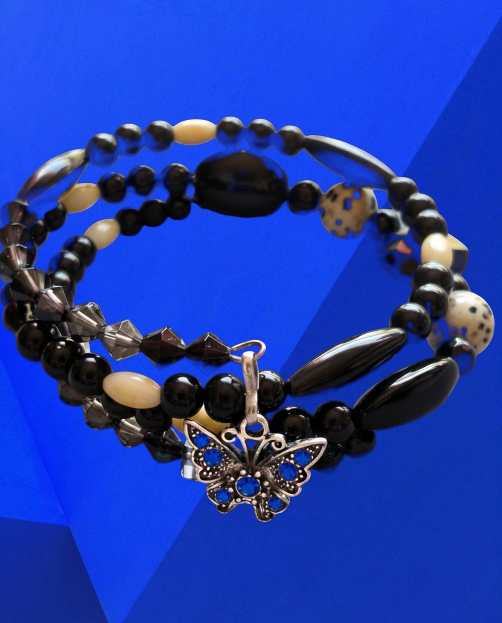 Heartfelt Creations wrap bracelet featuring black, white, and Dalmatian Jasper beads with a blue butterfly charm.