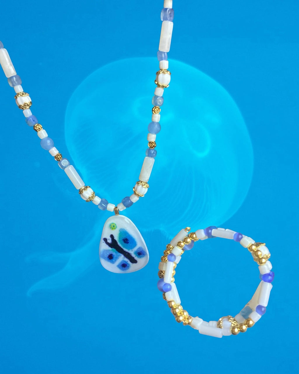 Heartfelt Creations handcrafted beaded necklace and bracelet set with a blue and green butterfly pendant on blue background