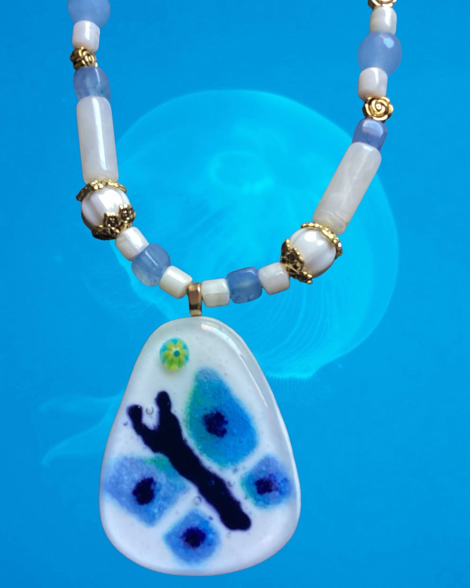 Heartfelt Creations handcrafted necklace with white and blue beads, gold spacers, and a blue butterfly pendant.