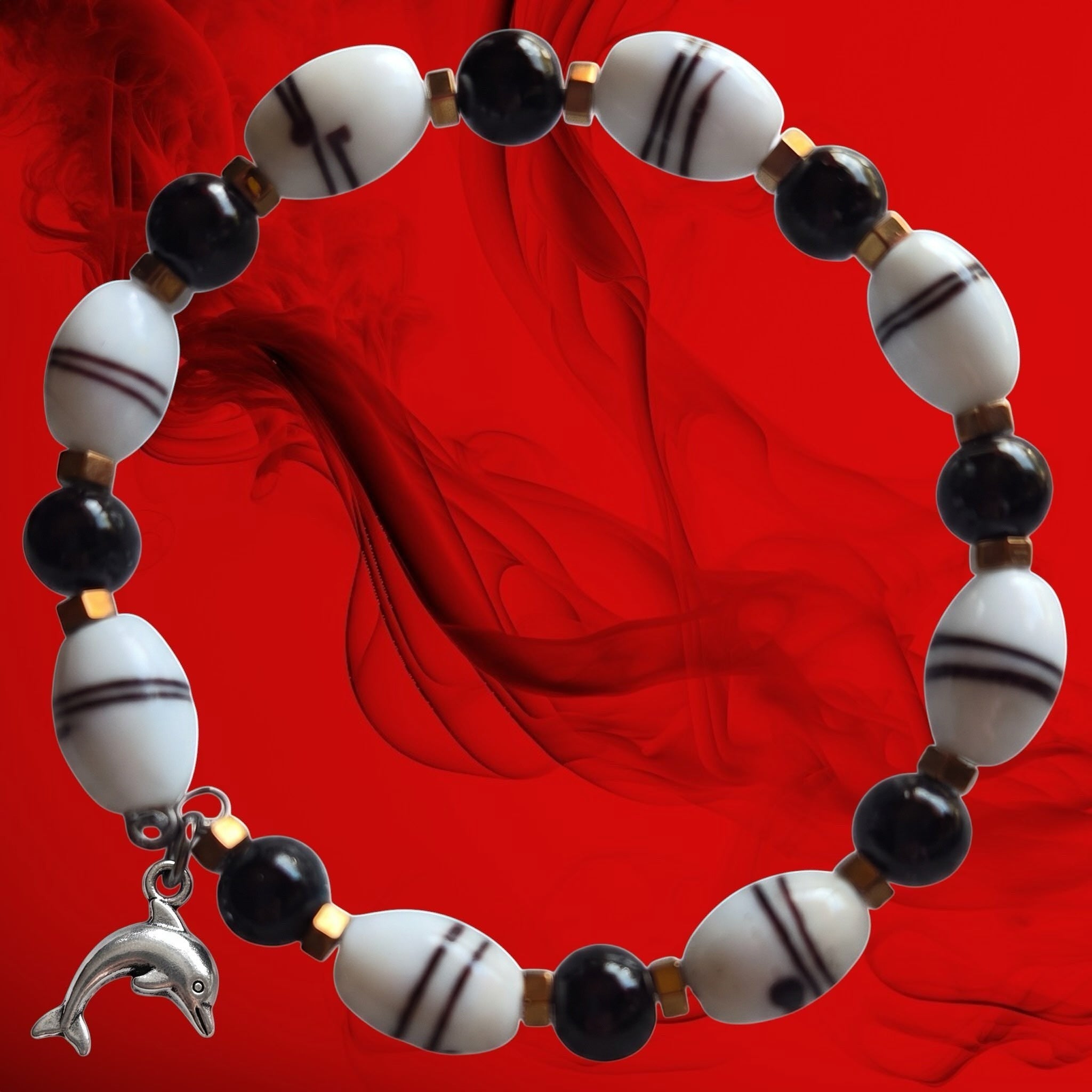 Heartfelt Creations beaded bracelet with black and striped white beads, metallic spacers, and a silver dolphin charm.