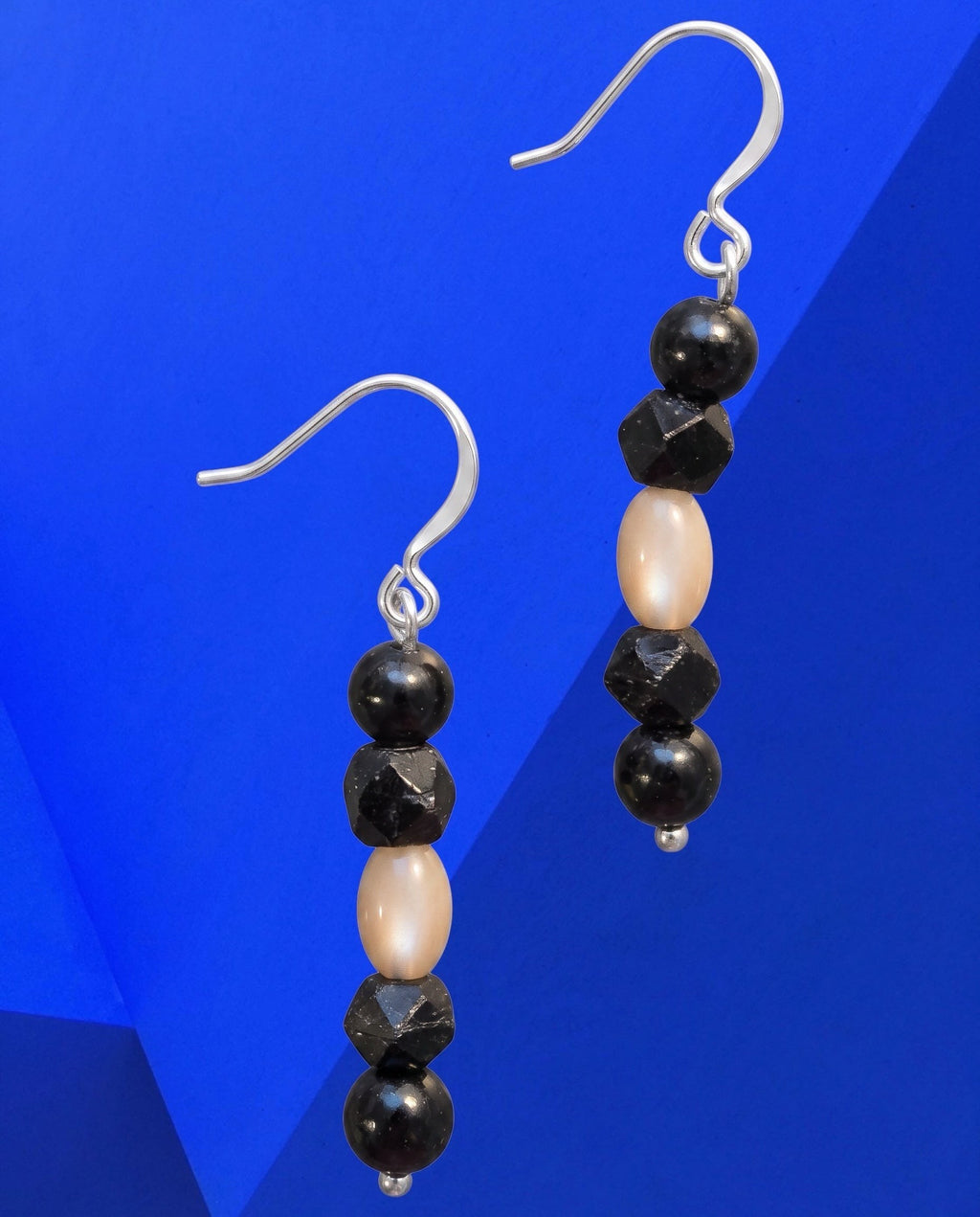 Heartfelt Creations drop earrings featuring alternating black faceted beads and smooth cream beads on silver hooks.
