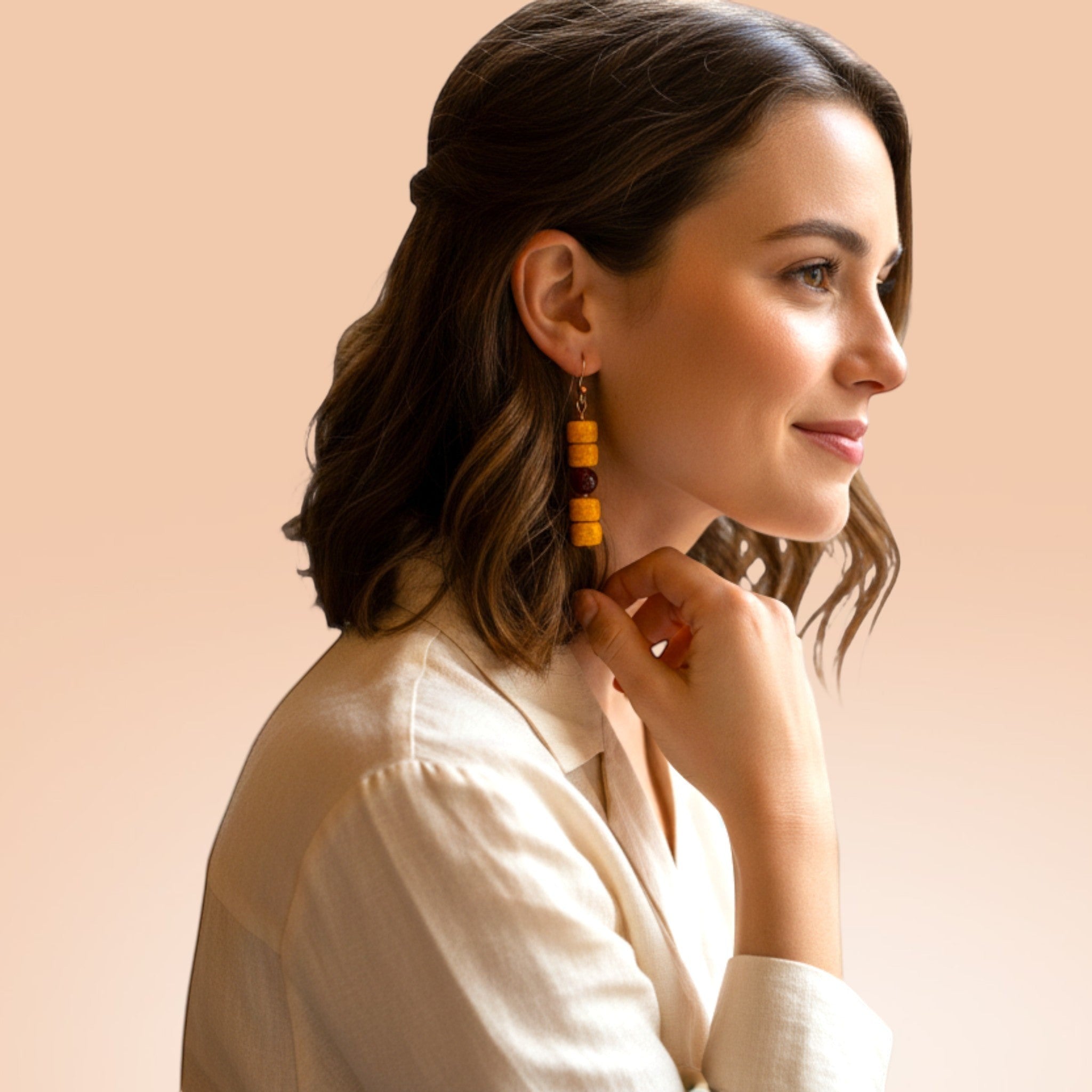 Heartfelt Creations bohemian drop earrings with yellow crackle and red beads worn by a woman in a white blouse