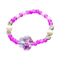 This delightful, hand crafted bracelet is a perfect way to add a pop to any outfit.   A beaded stretch bracelet features purple, lavendar and magenta beads, white pearl-like beads, silver-toned spacer details, and a central clear acrylic flower charm.  Simple yet Stunning!