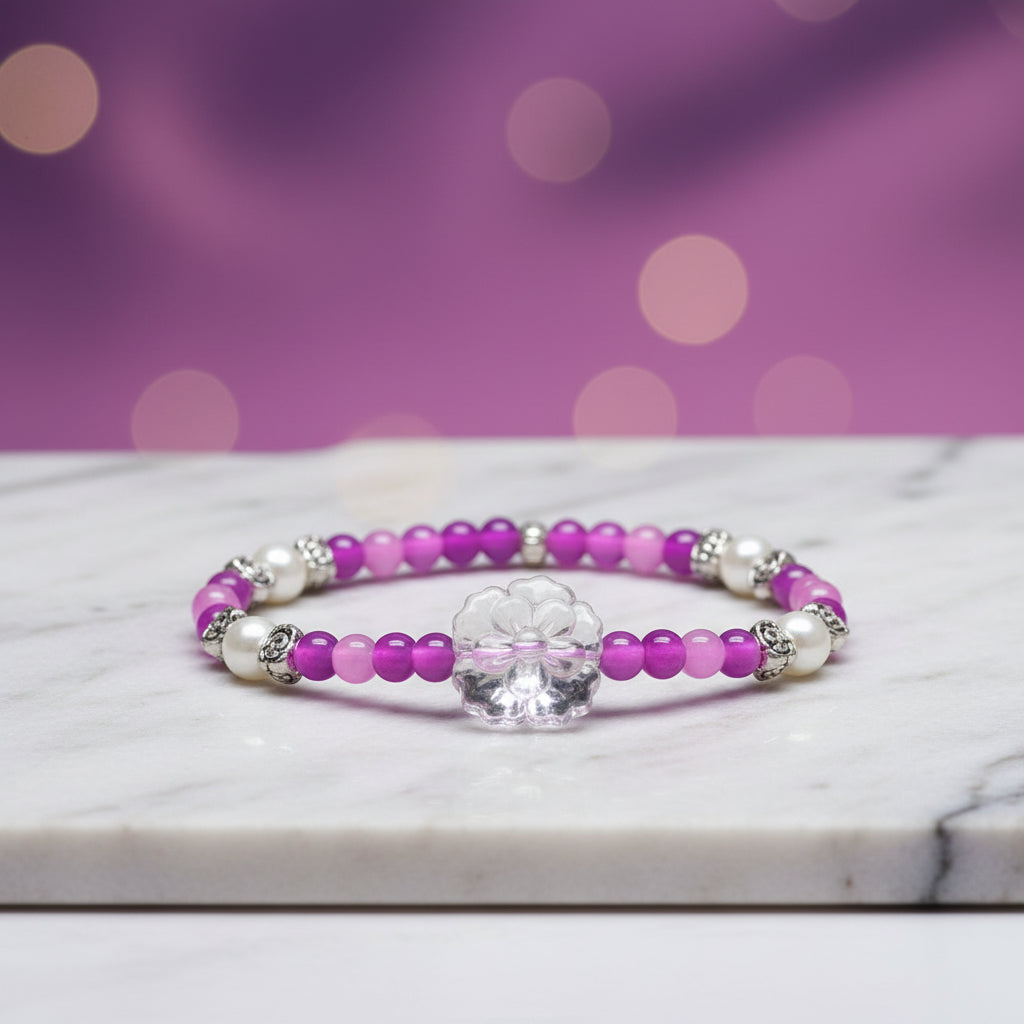 This delightful, hand crafted bracelet is a perfect way to add a pop to any outfit.   A beaded stretch bracelet features purple, lavendar and magenta beads, white pearl-like beads, silver-toned spacer details, and a central clear acrylic flower charm.  Simple yet Stunning!