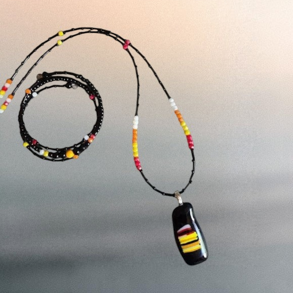 Heartfelt Creations handcrafted jewelry set with a black fused glass pendant necklace and matching beaded wrap bracelet.