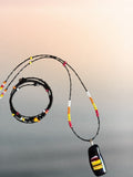 Heartfelt Creations handcrafted jewelry set with a black fused glass pendant necklace and matching beaded wrap bracelet.