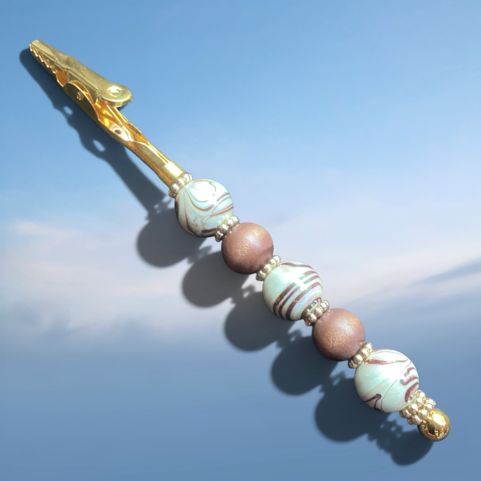 Heartfelt Creations gold-tone metal roach clip with decorative marbled glass and matte earthy beads.