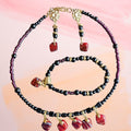 Heartfelt Creations beaded jewelry set with black, red, and gold-tone beads and dangle charms.