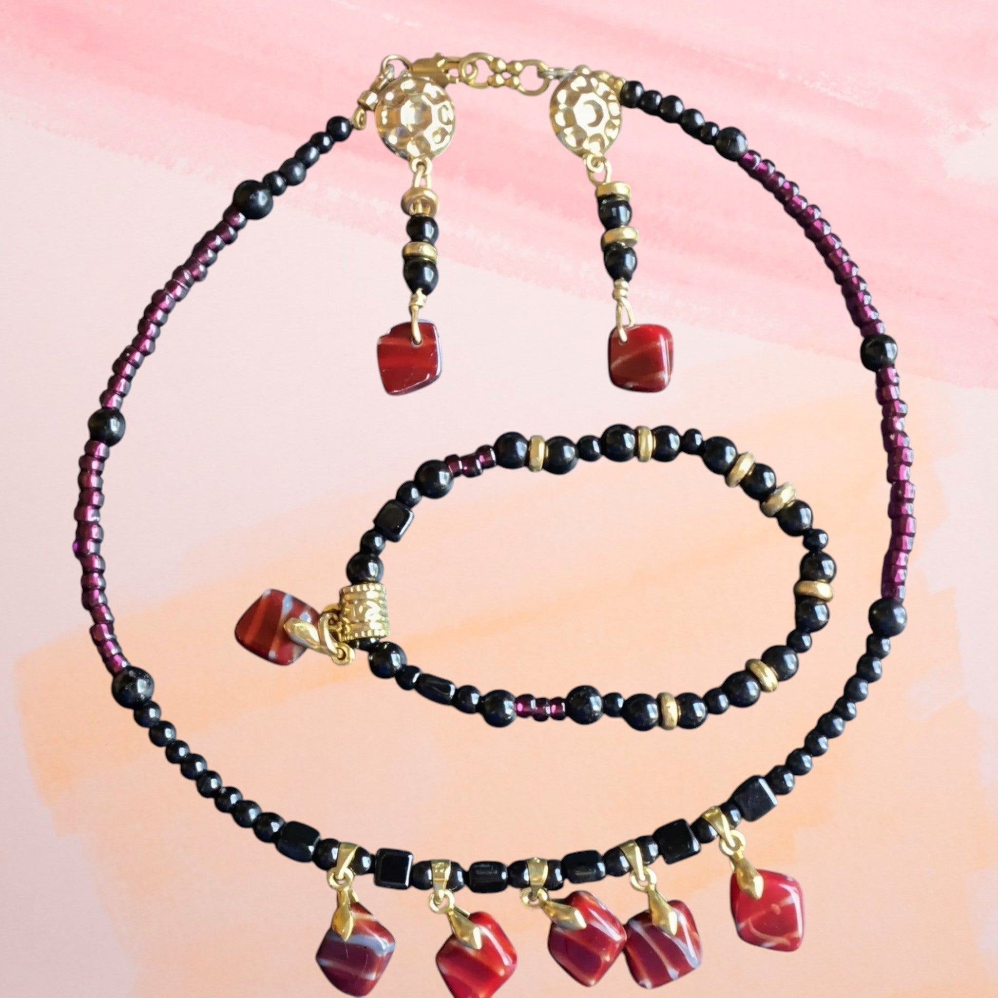Heartfelt Creations beaded jewelry set with black, red, and gold-tone beads and dangle charms.