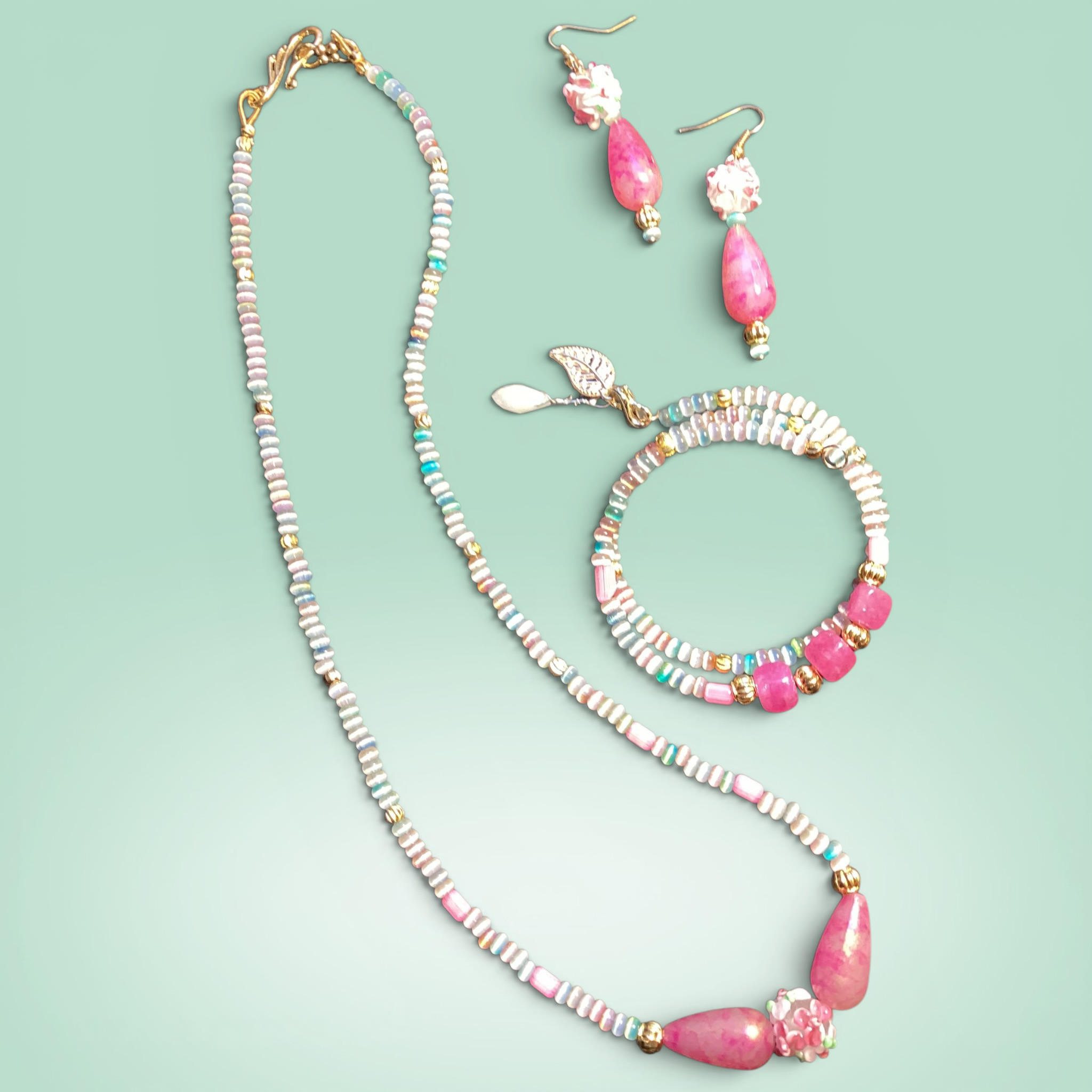 Heartfelt Creations beaded jewelry set with necklace, bracelet, and earrings featuring pink jade-like stones and iridescent beads.