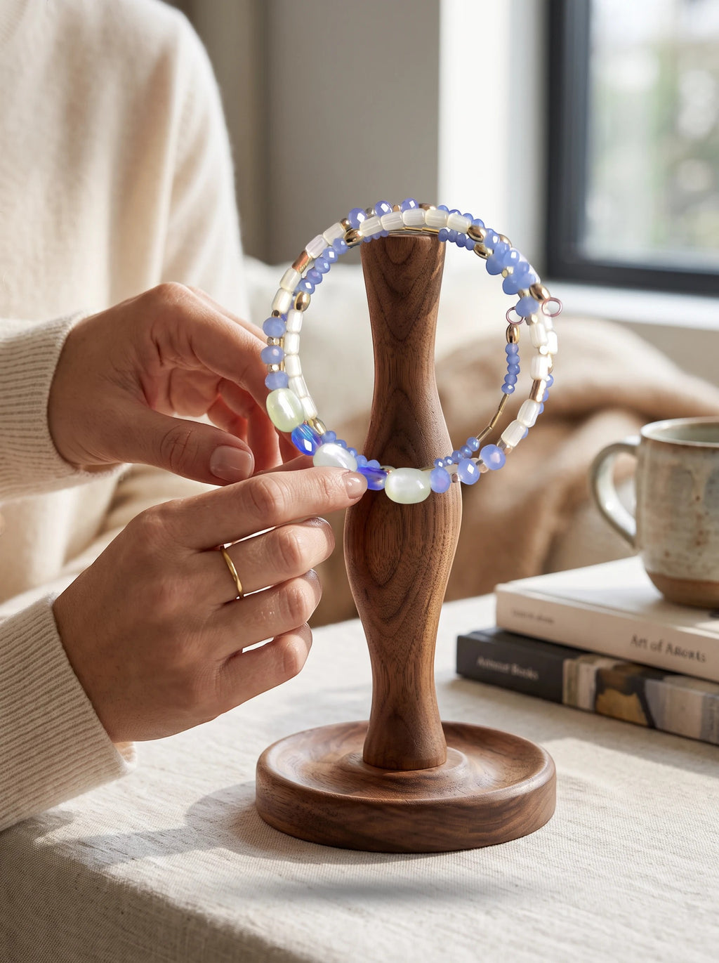 Heartfelt Creations artisan beaded necklace and bracelet set with blue, clear, and violet stones on a wooden stand.