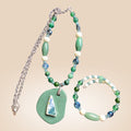 Heartfelt Creations artisan beaded necklace and wrap bracelet set in green, blue, and off-white with organic pendant.