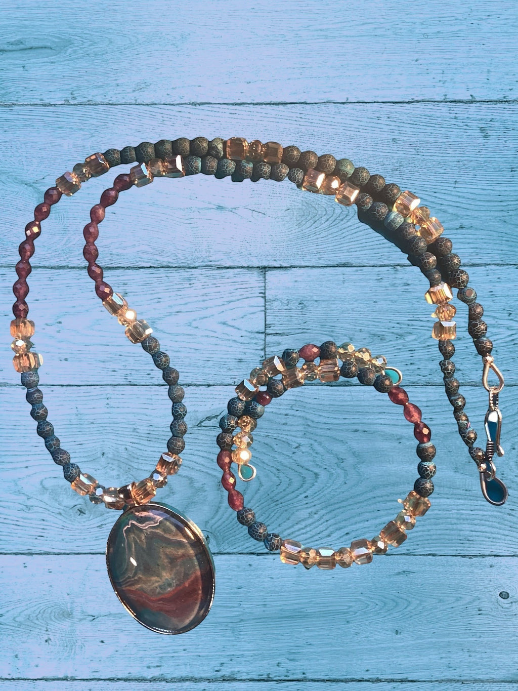 Heartfelt Creations artisan jewelry set featuring a marbled oval pendant, blue-grey agate beads, and amber crystal cubes.