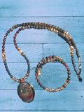 Heartfelt Creations artisan jewelry set featuring a marbled oval pendant, blue-grey agate beads, and amber crystal cubes.