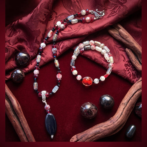 Heartfelt Creations artisan beaded necklace and bracelet set featuring black, red, and grey beads with a black pendant.
