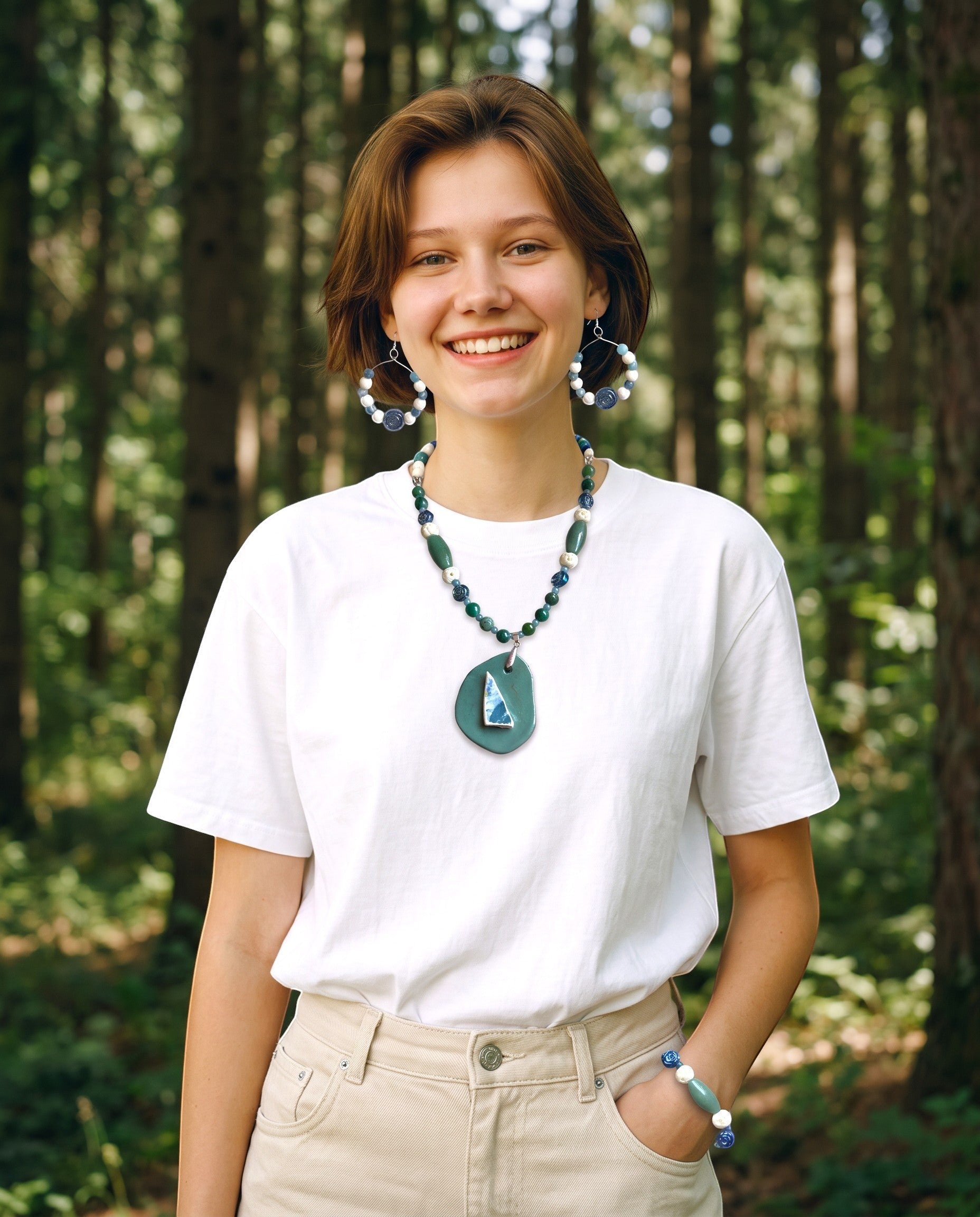 Heartfelt Creations artisan jewelry set with beaded necklace, hoop earrings, and bracelet worn by a smiling woman