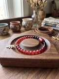 Heartfelt Creations beaded wire wrap bracelet with crimson matte beads, black accents, and a gold-toned leaf charm.