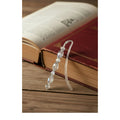 Heartfelt Creations handcrafted metal bookmark with iridescent crystal beads resting on a vintage hardcover book