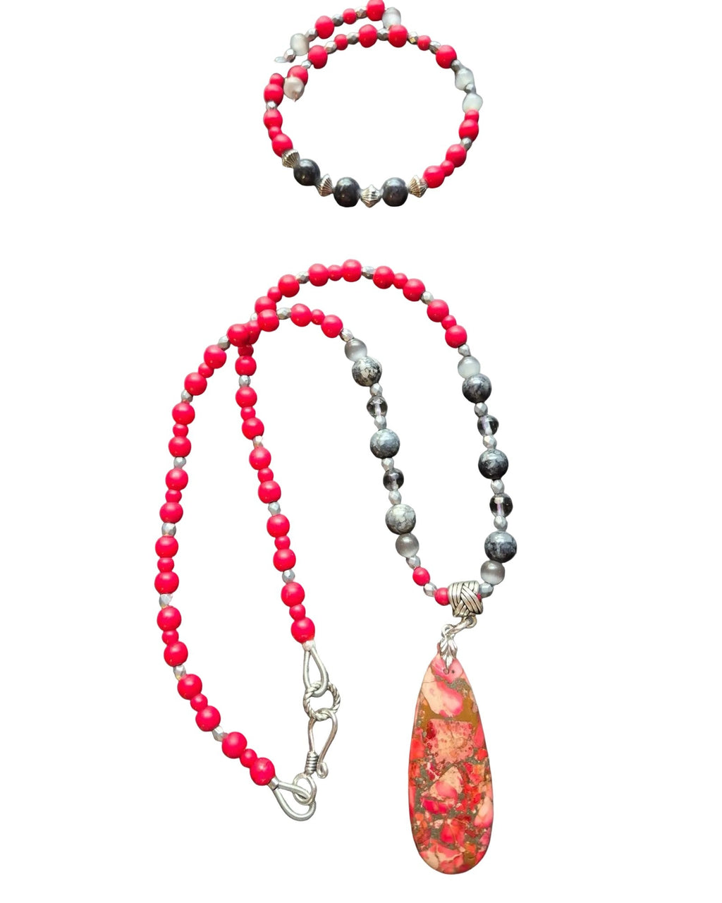 A beaded necklace with a teardrop pendant of Sediment Jasper and a matching beaded bracelet, featuring bright pink-red beads, dark gray marbled beads, and silver-toned spacers, 