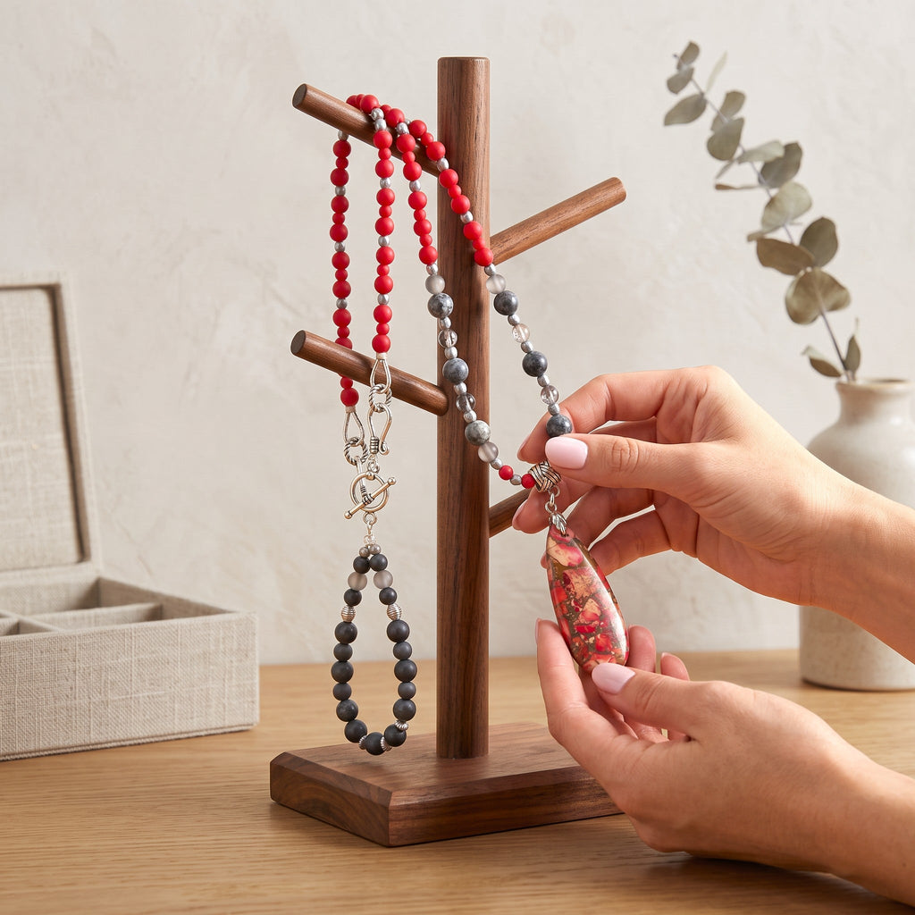 Heartfelt Creations beaded necklace and wrap bracelet set with a red marbled teardrop pendant on a wooden stand